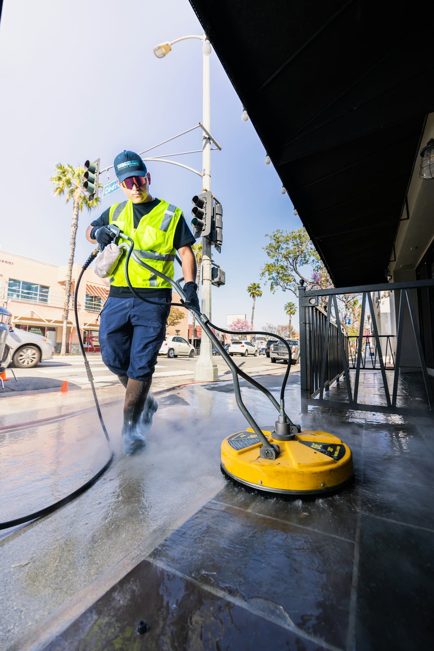 A commercial surface cleaner running across wet concrete, steam rising