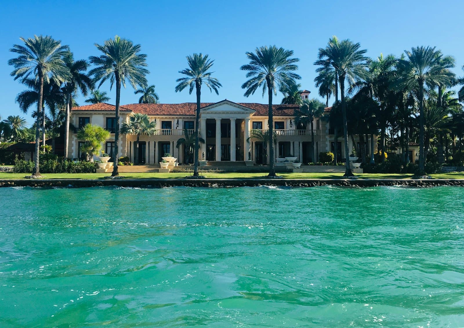 A waterfront Miami home lined with palms